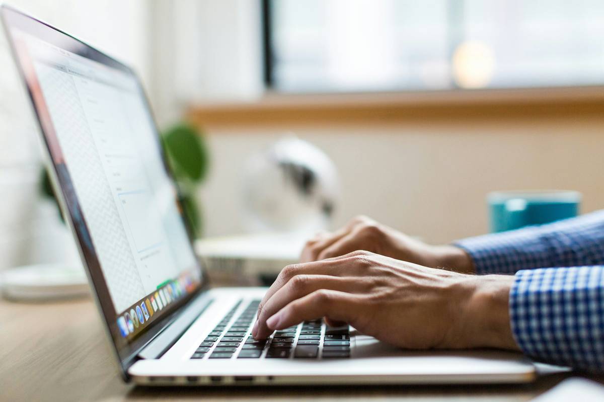 Laptop dan ponsel di meja kerja untuk artikel membaca syarat bonus Ug234